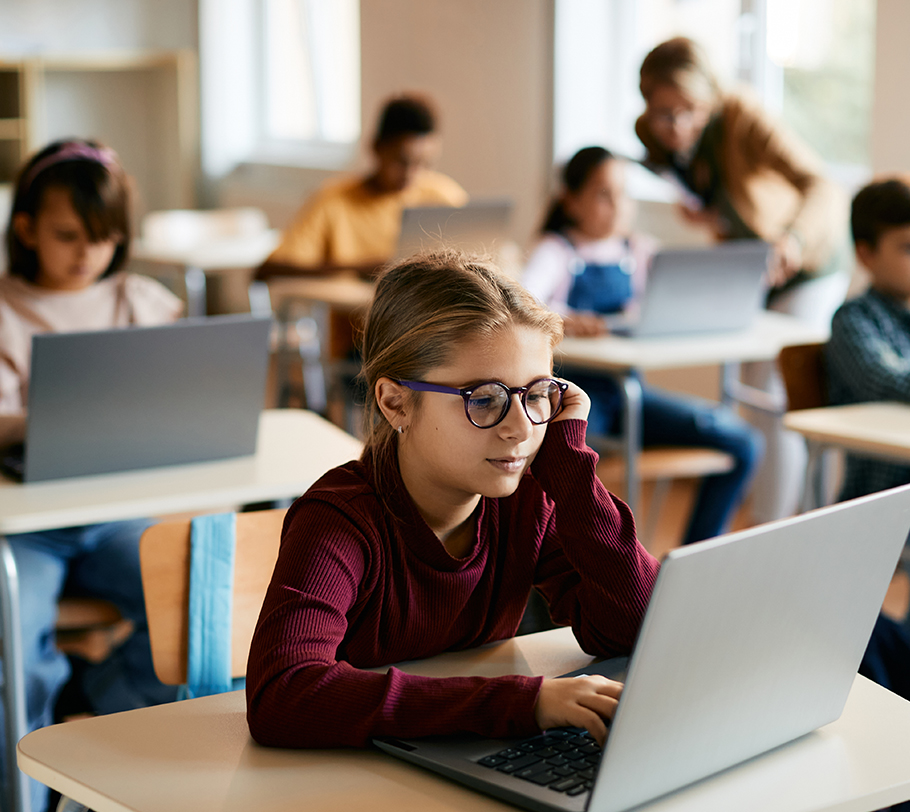 Classroom of students online learning Classroom full of kids using laptops